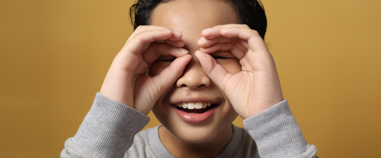 Pojke som gör en kikare av sina händer