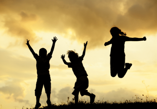Bild på barn som hoppar i en solnedgång.