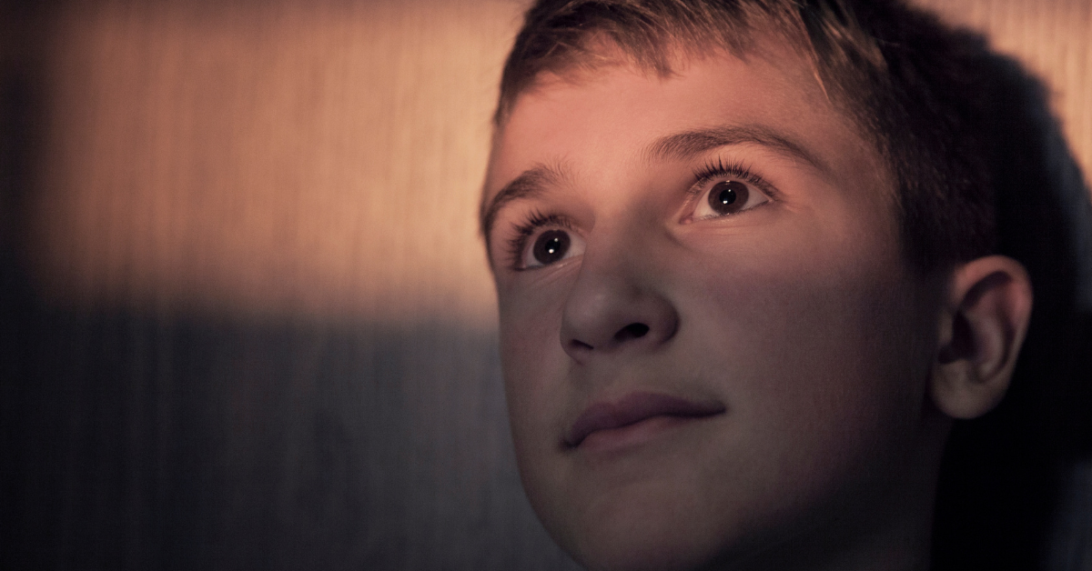 Bild på en pojke som tittar långt bort.